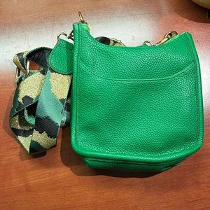 MINI SADDLE BAG IN VEGAN LEATHER IN KELLY GREEN with camo patterned strap.